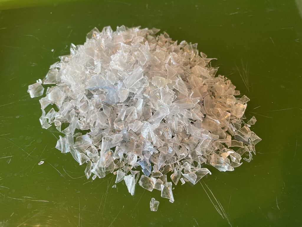 A small pile of recycled plastic flakes on a green background